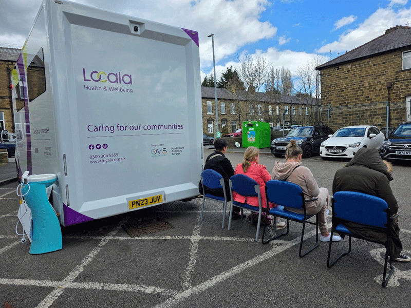 People waiting outside a mobile van for a cervical screening in Kirklees