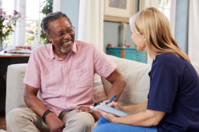 Practitioner and resident talking while seated on a couch
