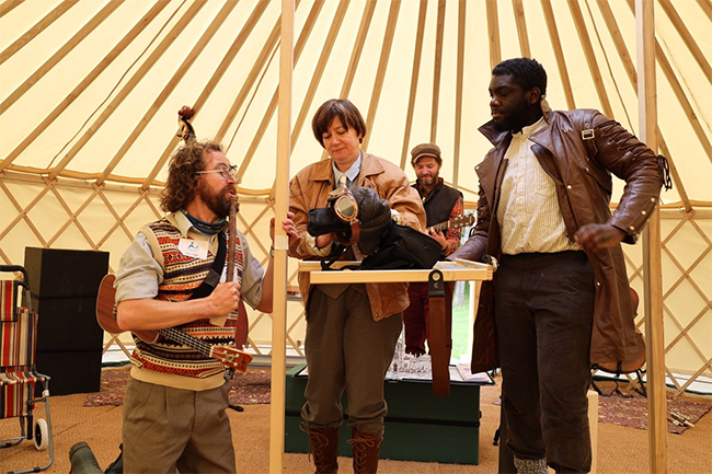 In a Mongolian yurt, four actors are performing with a ukulele and a puppet
