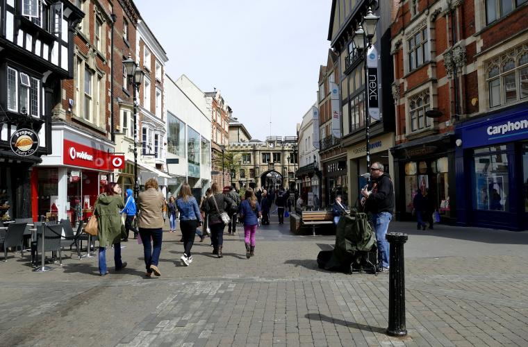 Bustling pedestrianised high street with shops and cafes
