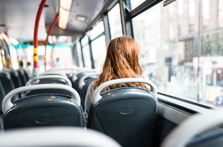 A girl sat on a bus looking out the window