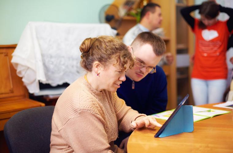 photo of woman and man looking at a computer