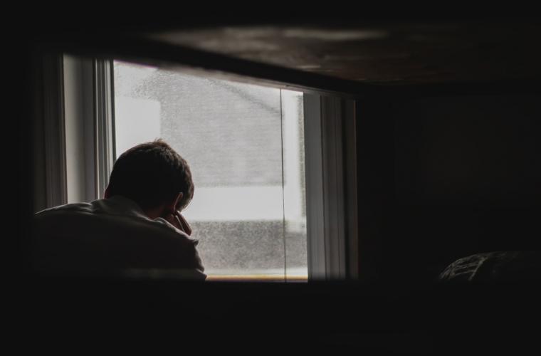 man in a dimly lit room looking stressed