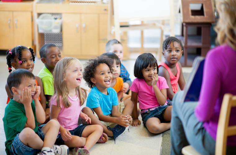 Children sitting and listening to a story in a library