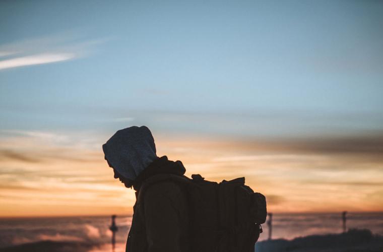 man looking at sea rucksack on back